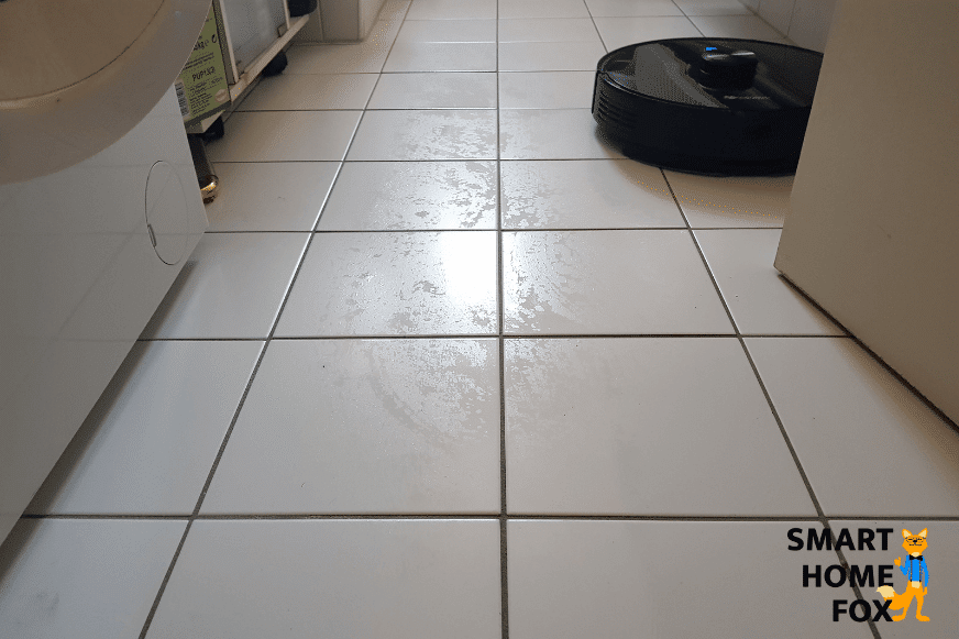 Proscenic M7 Pro протирает плиточный пол в ванной комнате.